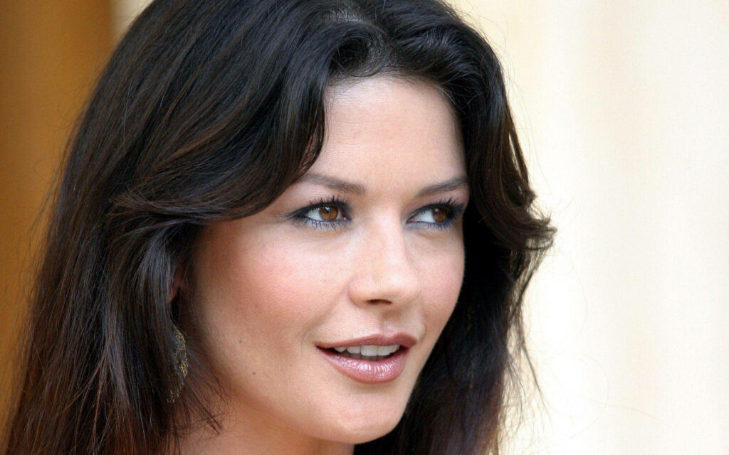 Close-up portrait of Catherine Zeta-Jones with flawless skin and elegant features in soft lighting Wallpaper