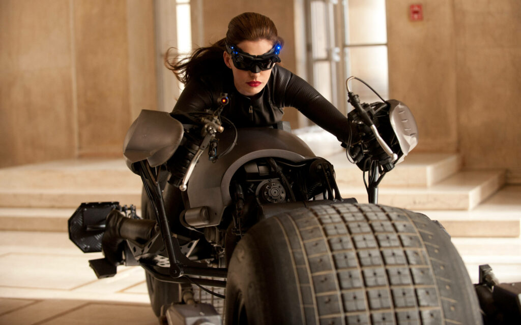 Catwoman riding Batpod in sleek black suit and goggles through corridor action scene wallpaper