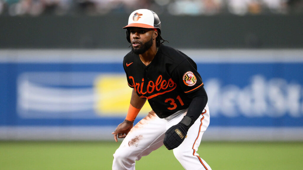 Cedric Mullins Baltimore Orioles in black orange uniform poised on field during pro baseball game action Wallpaper