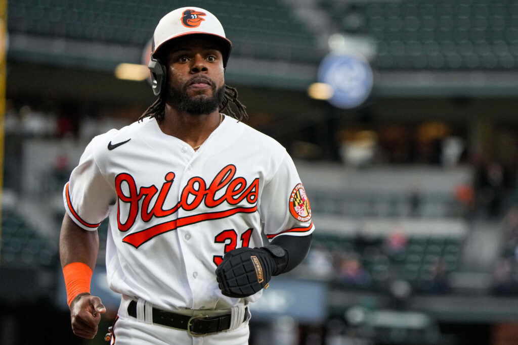 Cedric Mullins Baltimore Orioles intense focus in white orange uniform blurred stadium background Wallpaper