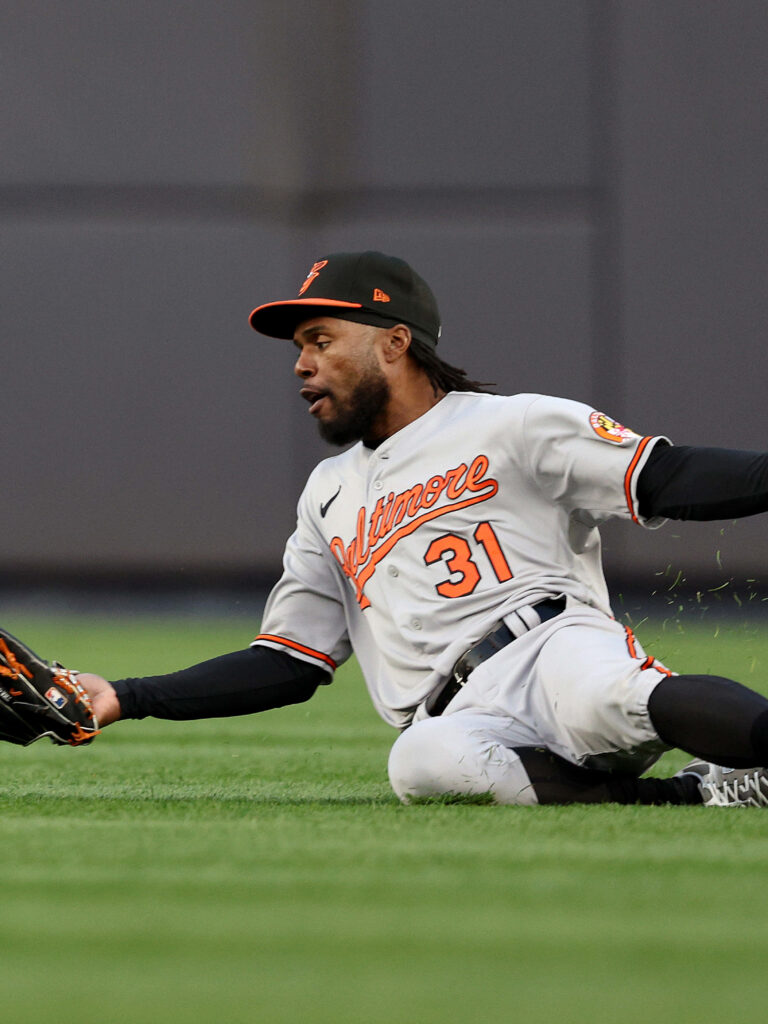 Cedric Mullins slides on green grass in Baltimore Orioles uniform number 31 dynamic baseball wallpaper
