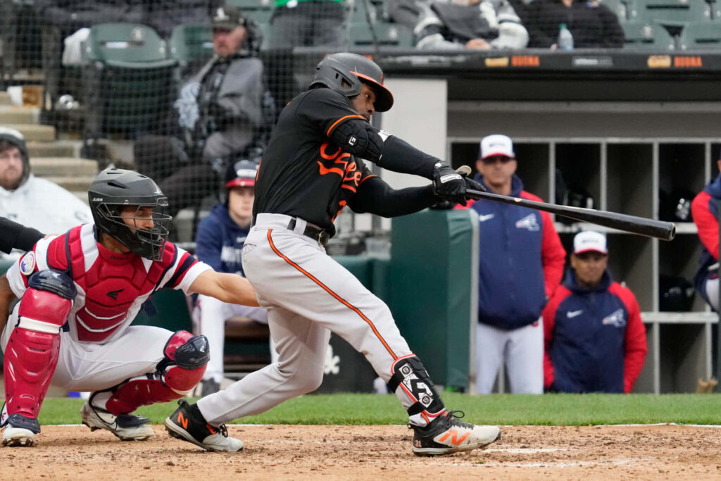 Cedric Mullins mid-swing at bat with catcher behind in lively stadium baseball action wallpaper