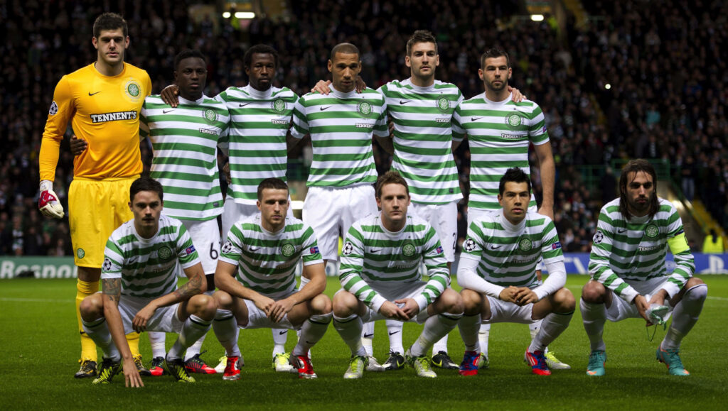 Celtic FC team in green white hoops lineup on pitch with vibrant stadium crowd match day energy Wallpaper