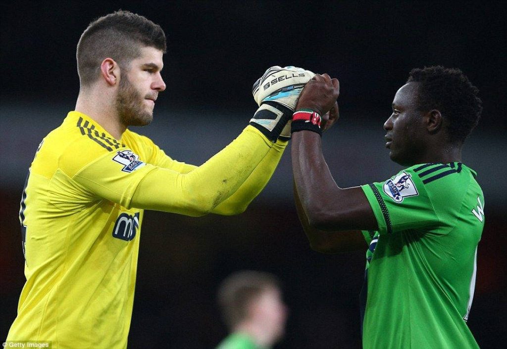 Celtic goalkeeper Fraser Forster in yellow kit celebrates with teammate Victor Wanyama on pitch Wallpaper