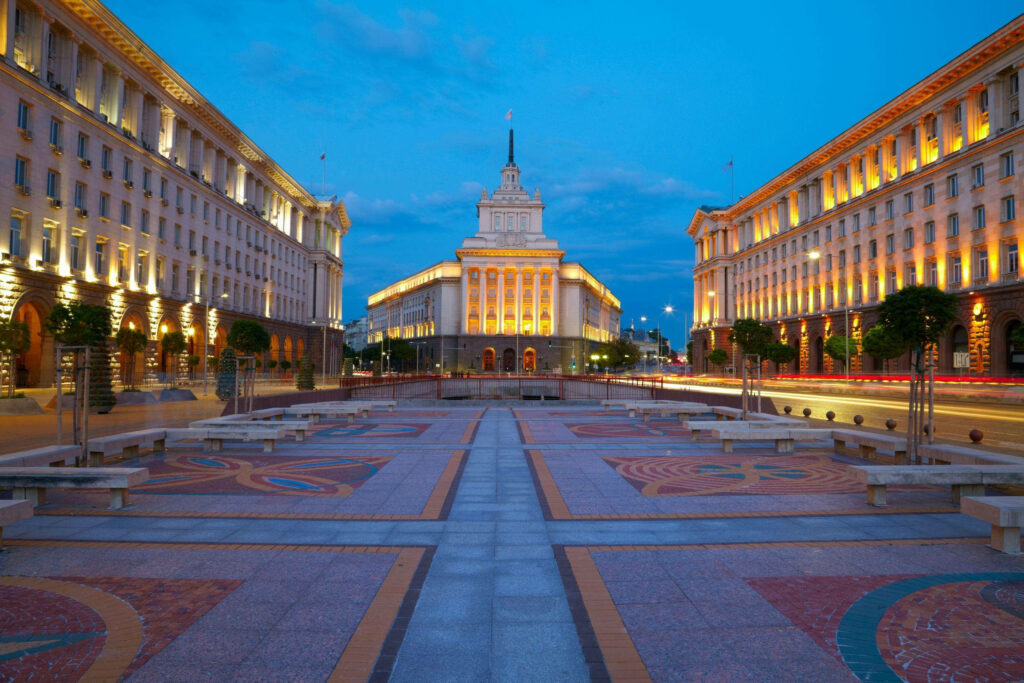 Central Independence Square Sofia at dusk with neoclassical buildings and patterned tiled plaza Wallpaper