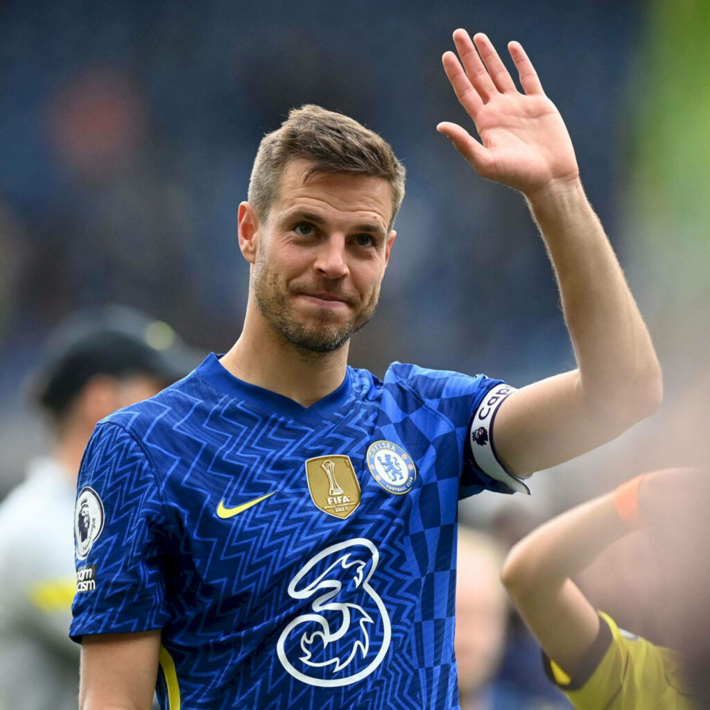 César Azpilicueta in Chelsea blue home kit waving to fans at vibrant stadium wallpaper background