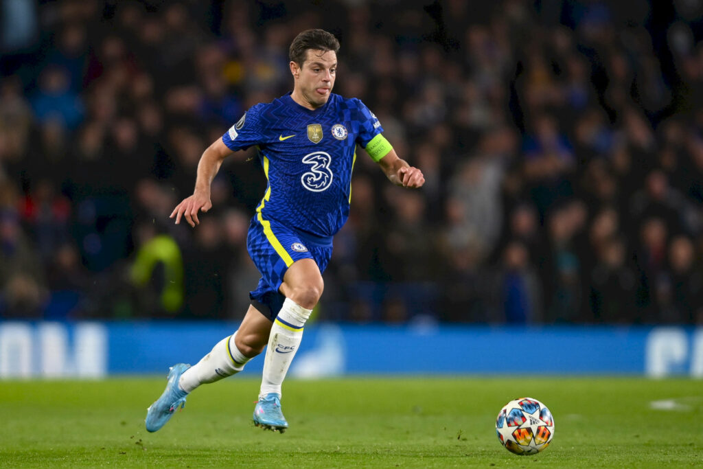 César Azpilicueta sprinting in blue Chelsea kit during intense football match under stadium lights Wallpaper