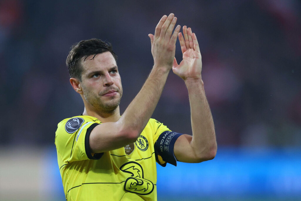 César Azpilicueta applauding in yellow Chelsea captain jersey with vibrant stadium background Wallpaper