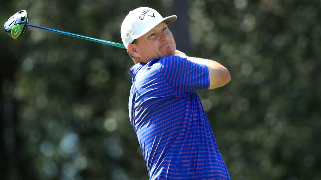 Chad Campbell swinging golf club focused in blue striped shirt white cap on lush green course Wallpaper