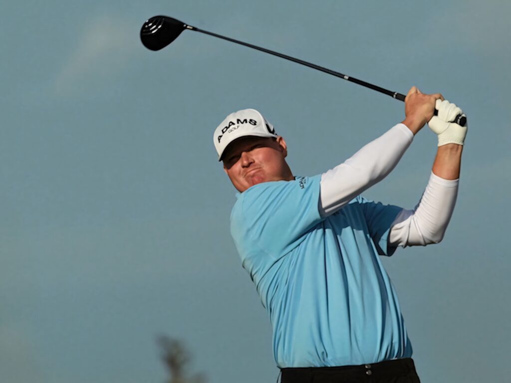 Chad Campbell mid-swing golf wallpaper with focused stance crisp attire and clear blue sky background