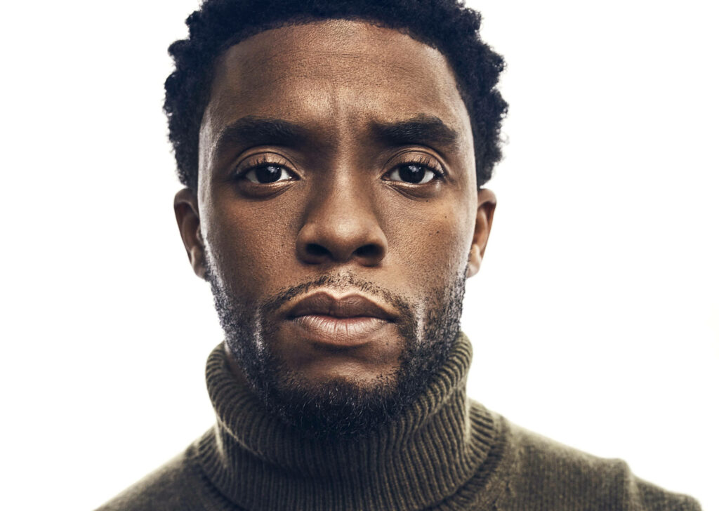 Close-up portrait of Chadwick Boseman with expressive gaze and textured skin on minimalist background Wallpaper