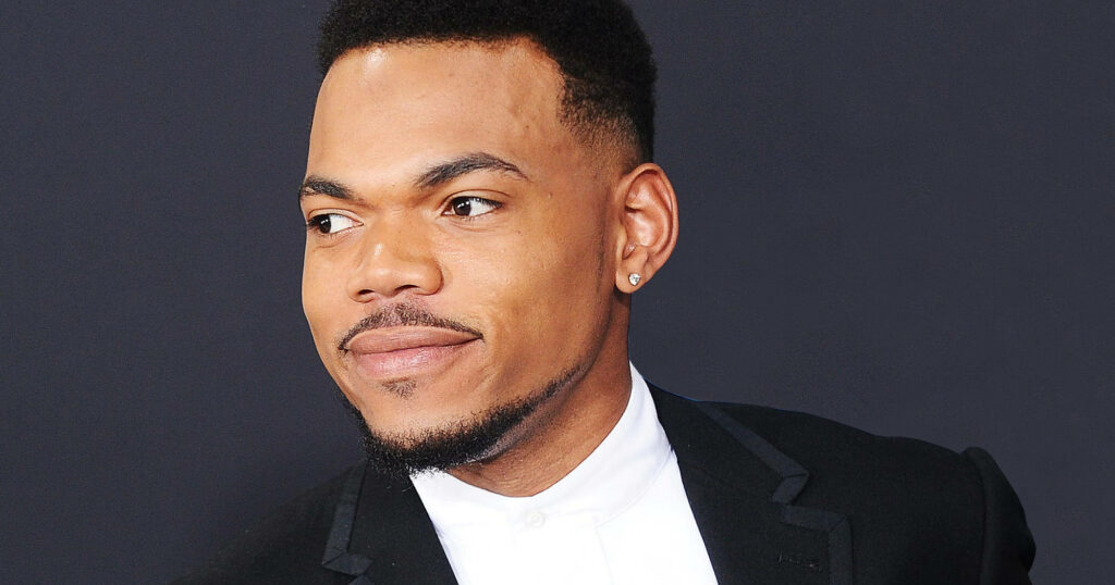 Chance The Rapper in sharp black suit white shirt confident pose dark background wallpaper