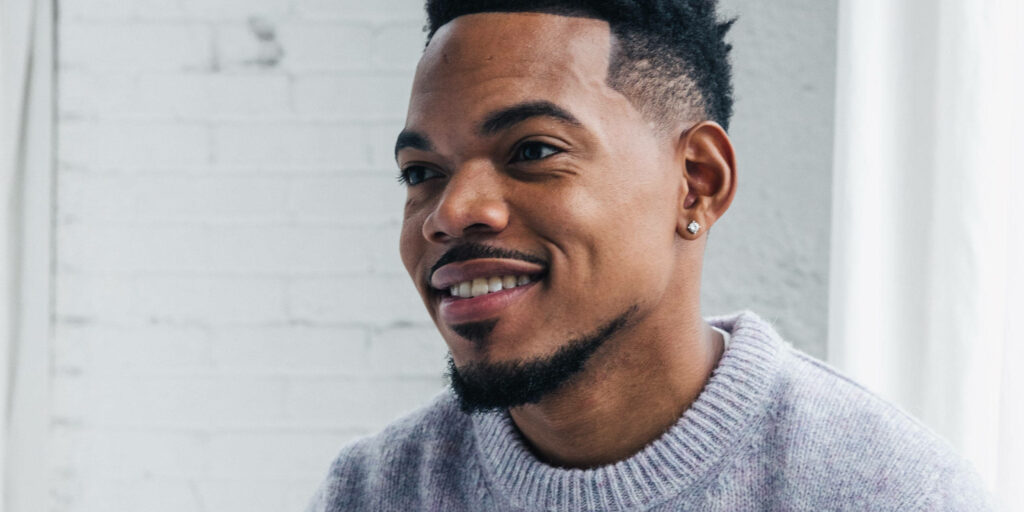 Chance The Rapper portrait smiling in light sweater on white brick wall bright airy background Wallpaper