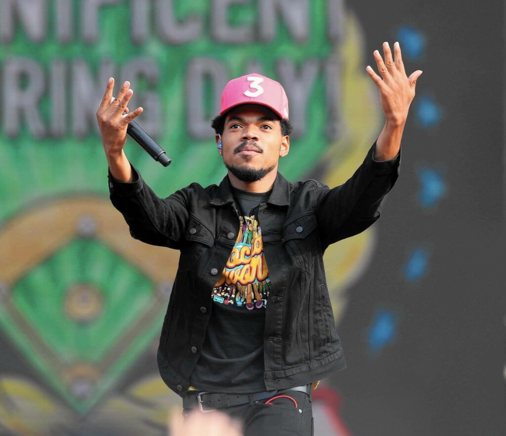 Chance The Rapper performing live wearing red 3 cap vibrant tee at outdoor concert stage background Wallpaper