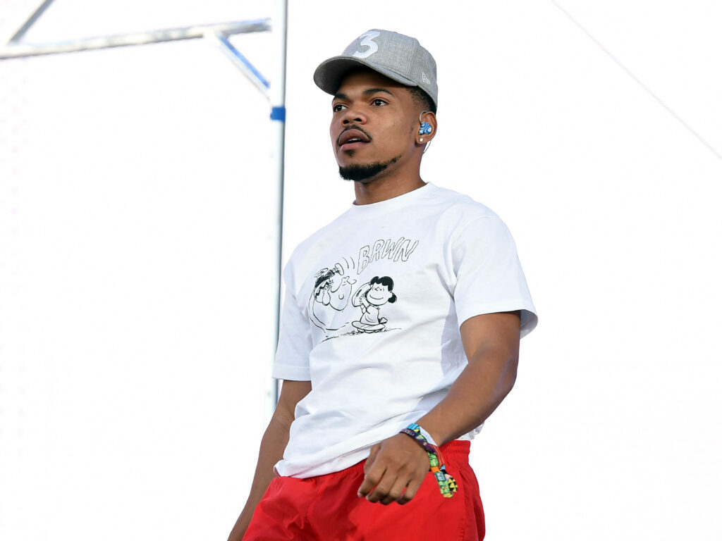 Chance The Rapper in gray cap white Peanuts Charlie Brown t-shirt and red pants outdoors wallpaper