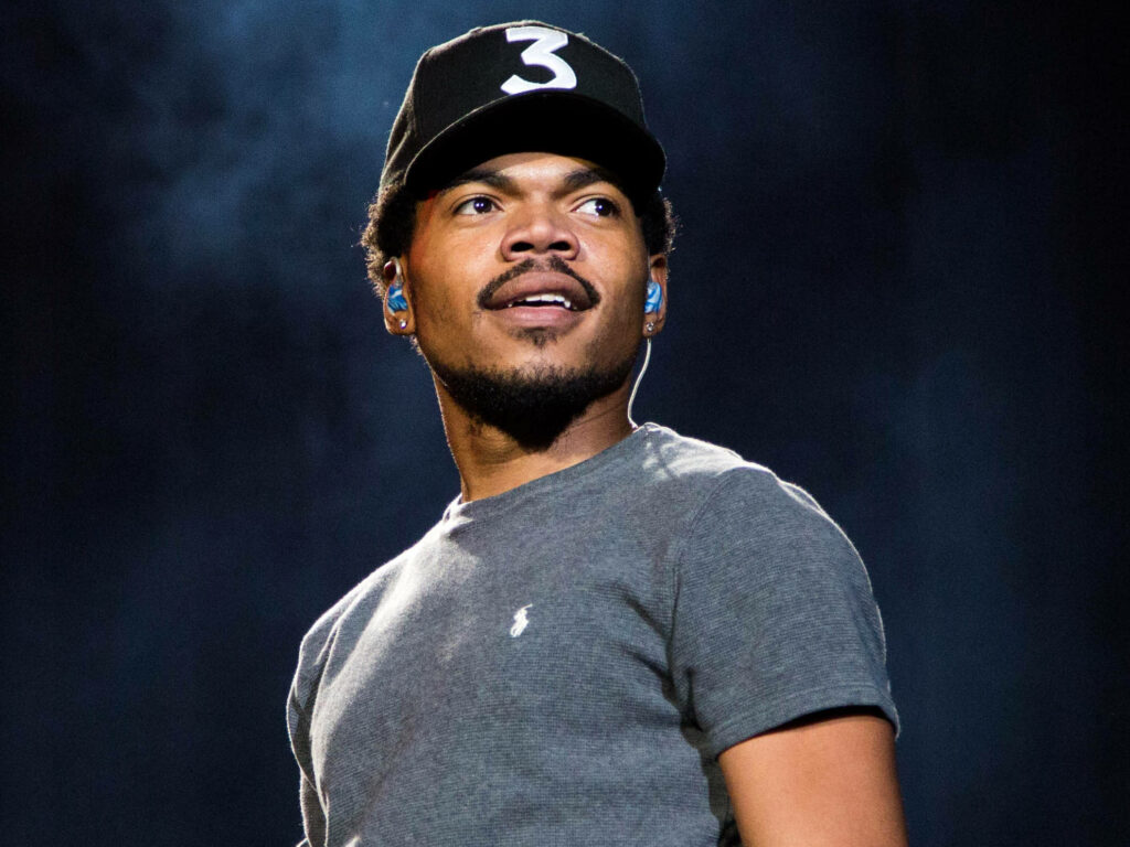 Chance The Rapper on stage wearing black hat number 3 dark shirt smoky dramatic background wallpaper
