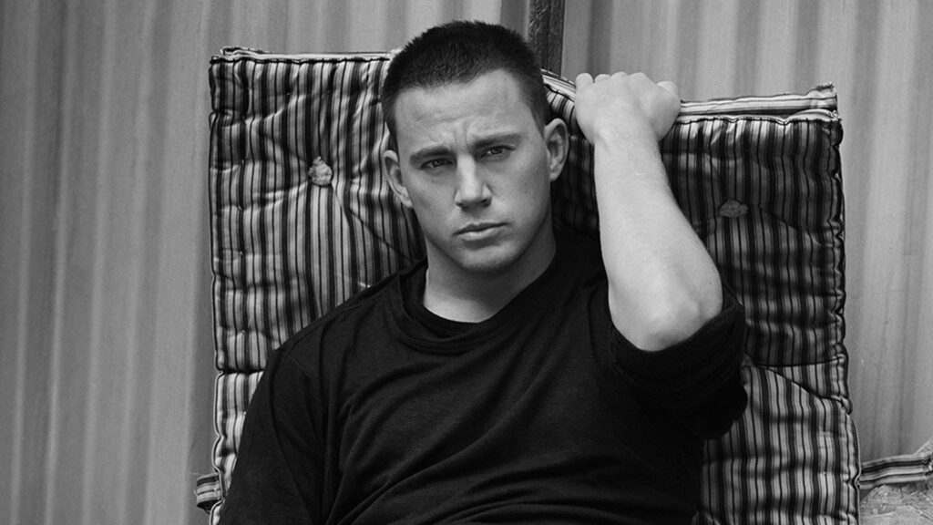 Channing Tatum grayscale wallpaper sitting on striped cushion wearing dark shirt thoughtful gaze