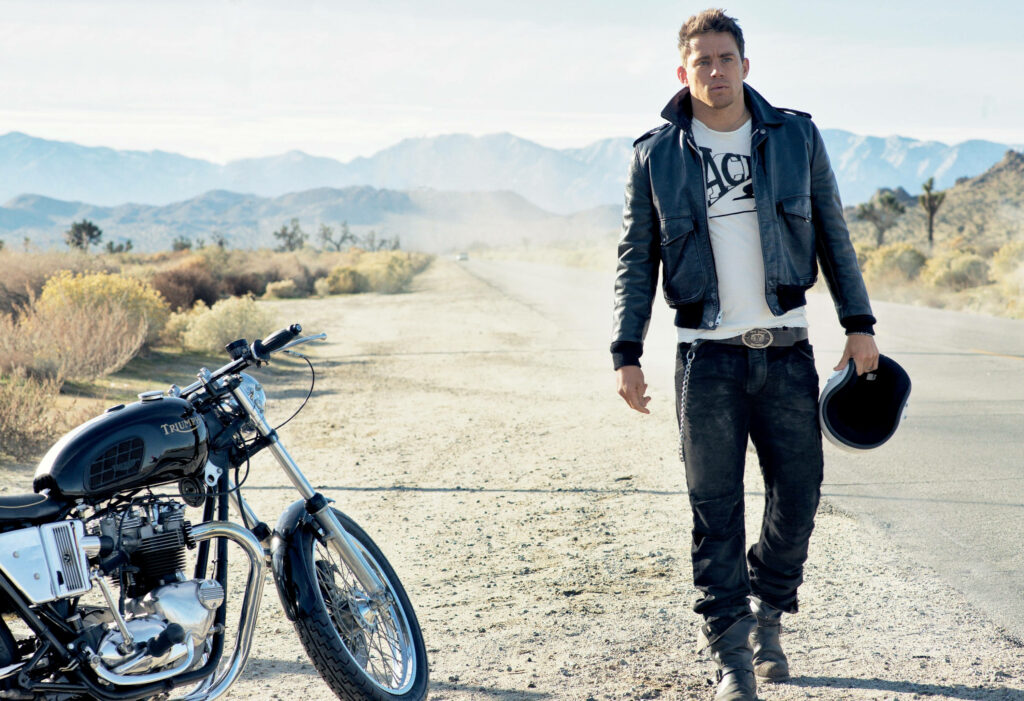 Channing Tatum confident in leather jacket by classic motorcycle on mountain road outdoor photoshoot Wallpaper
