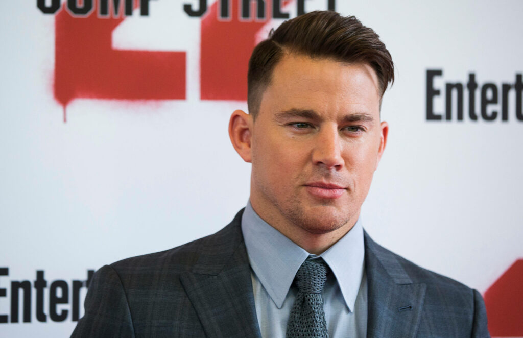 Channing Tatum in sharp suit posing confidently at Hollywood event wallpaper background
