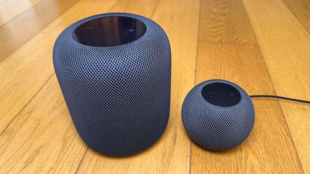 Charcoal Apple HomePod and HomePod mini on light wooden floor with bright natural light background Wallpaper