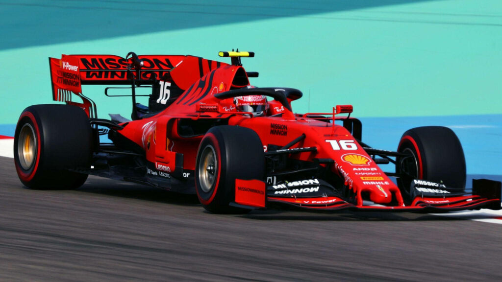 Charles Leclerc racing in red Ferrari F1 car on vivid green tarmac dynamic wallpaper background