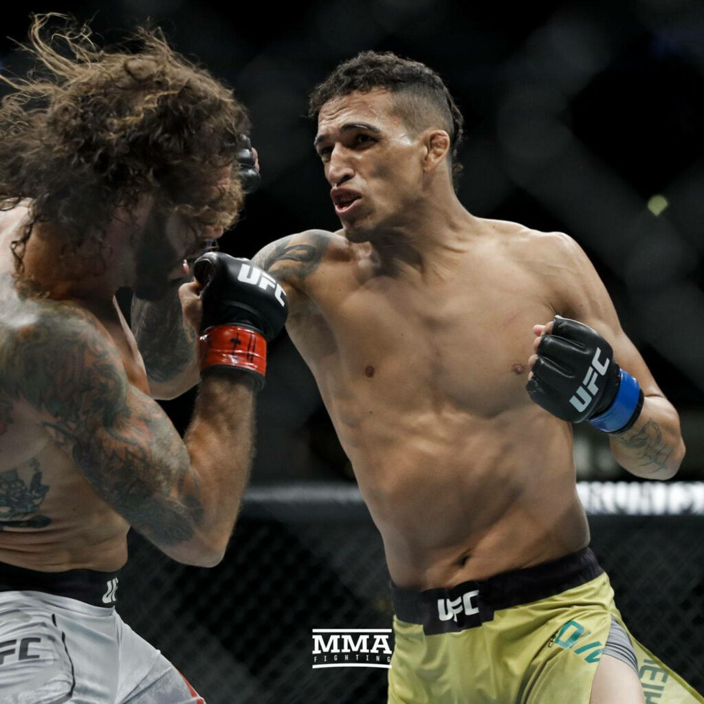Charles Oliveira delivering a powerful UFC punch in the octagon with intense fight action wallpaper