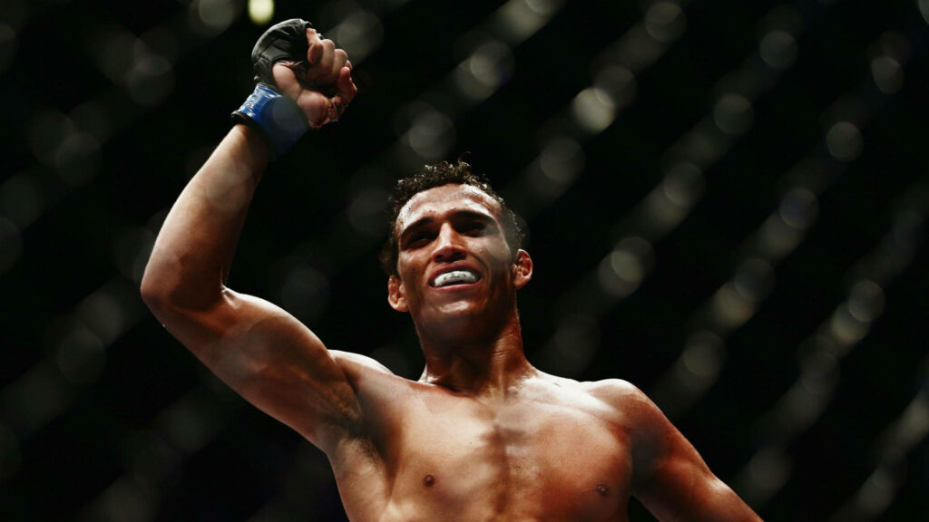 Charles Oliveira fist pump victory MMA octagon bright lights athletic physique intense fight Wallpaper