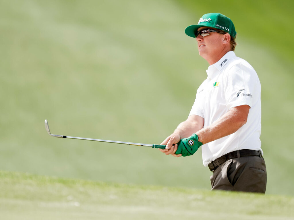 Charley Hoffman focused gripping golf club wearing white and green in bright professional tournament Wallpaper
