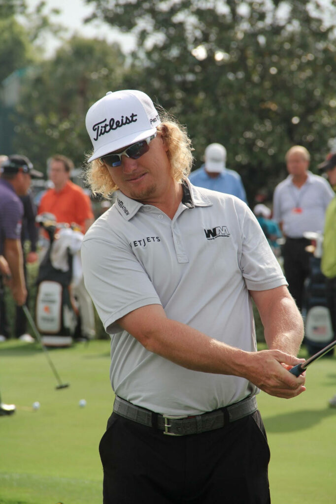 Charley Hoffman practicing golf on lush course wearing gray shirt white Titleist cap bright sun Wallpaper
