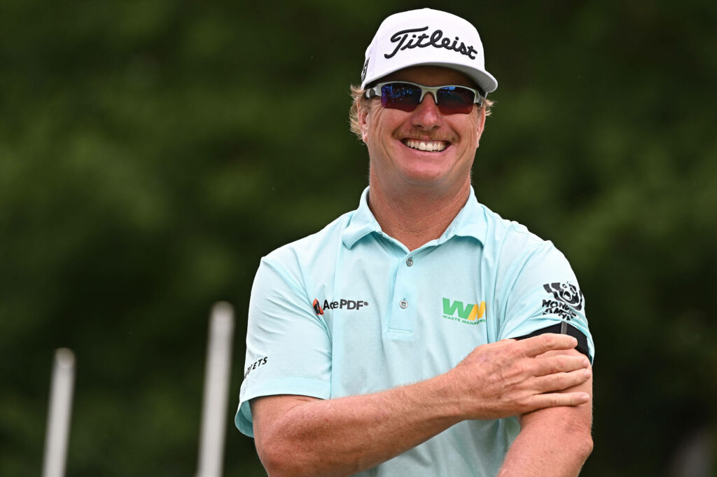 Charley Hoffman smiling in light blue golf shirt and white Titleist cap on green golf course Wallpaper