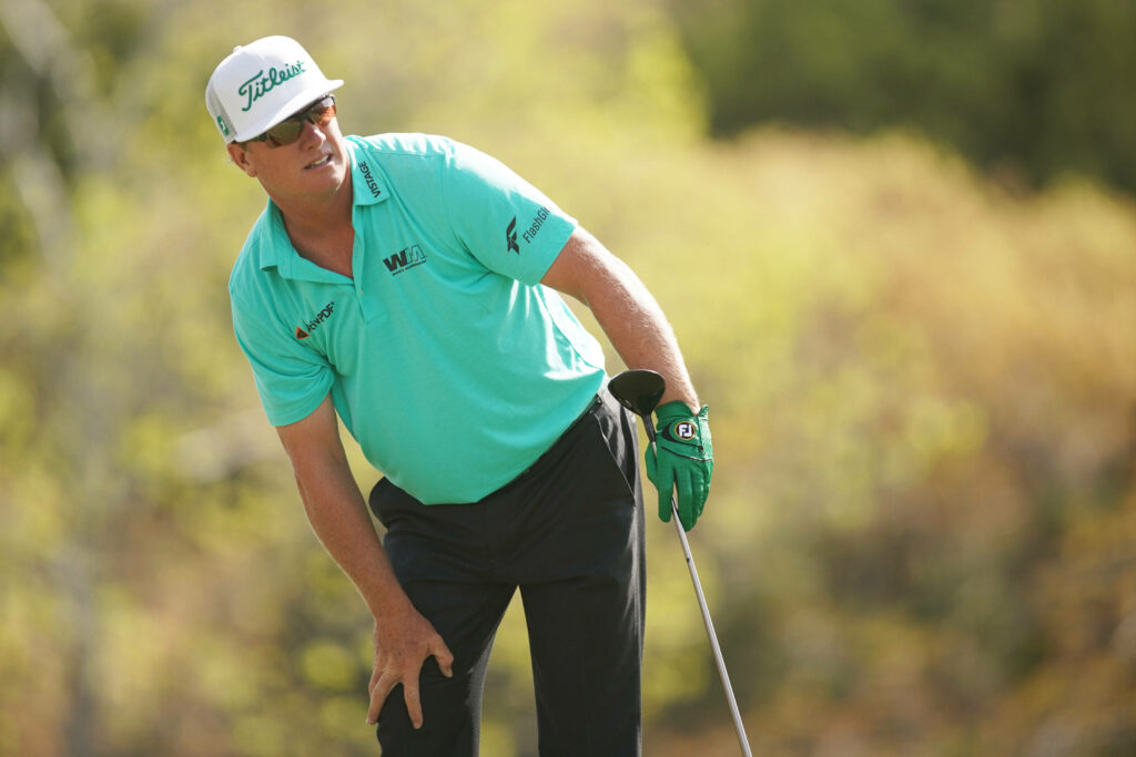 Charley Hoffman focused on golf course wearing cyan shirt green glove sunlit lush natural background Wallpaper