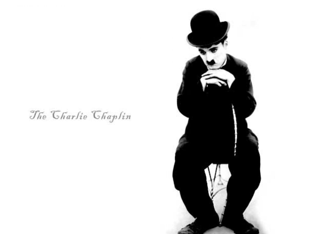 Charlie Chaplin reflective pose wallpaper iconic silent film legend vintage emotion background