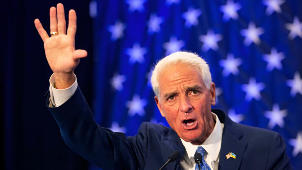 Charlie Crist speaking passionately with raised hand blue star background patriotic political speech Wallpaper
