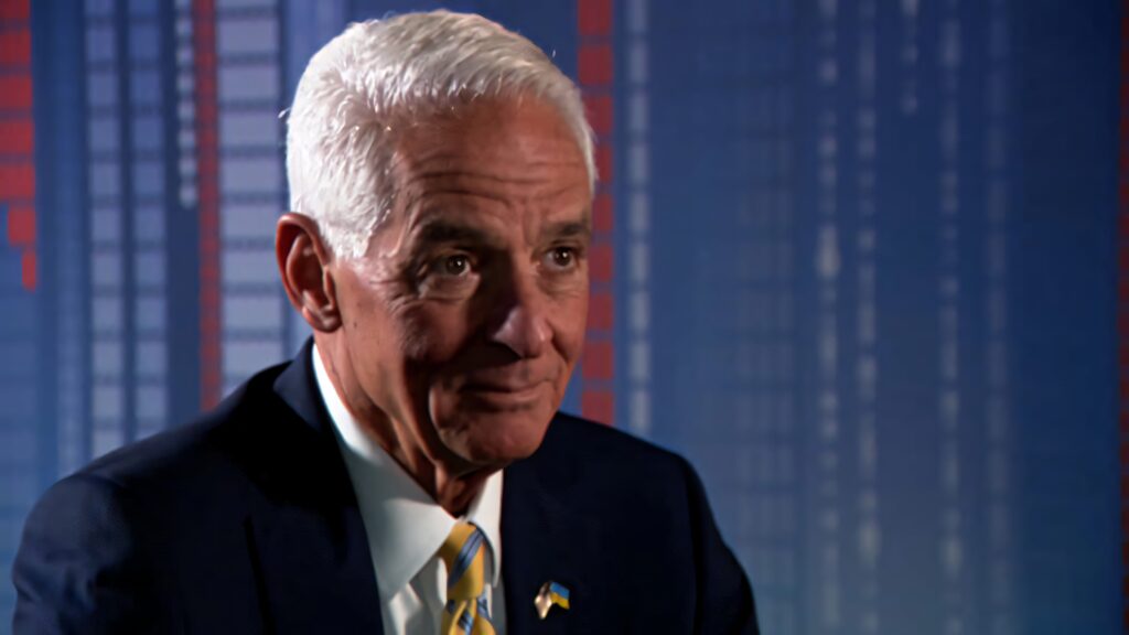 Professional portrait of Charlie Crist in dark suit with blue geometric background for politics Wallpaper