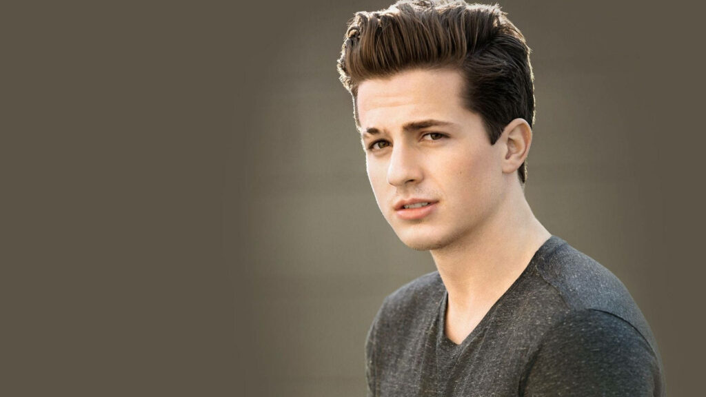 Charlie Puth minimal look wallpaper with soft neutral background and relaxed expression