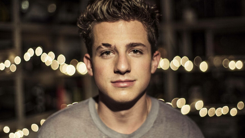 Charlie Puth portrait with twinkling lights blurred background warm inviting wallpaper