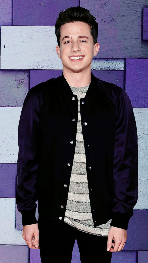 Charlie Puth in stylish jacket against modern purple background vibrant music wallpaper