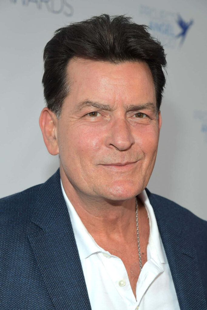Charlie Sheen in blue blazer white shirt confident pose neutral background professional portrait Wallpaper