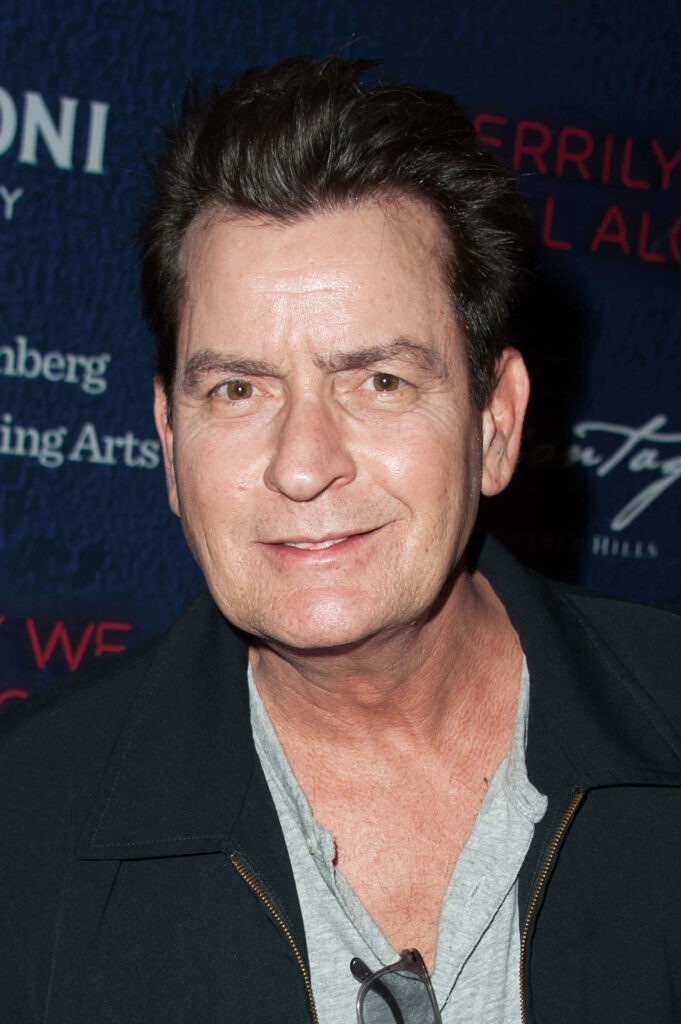 Charlie Sheen smiling candid portrait deep blue red event backdrop sharp well lit wallpaper