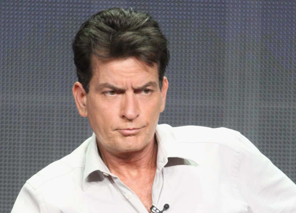 Charlie Sheen serious expression in light gray shirt dark textured background high resolution portrait Wallpaper