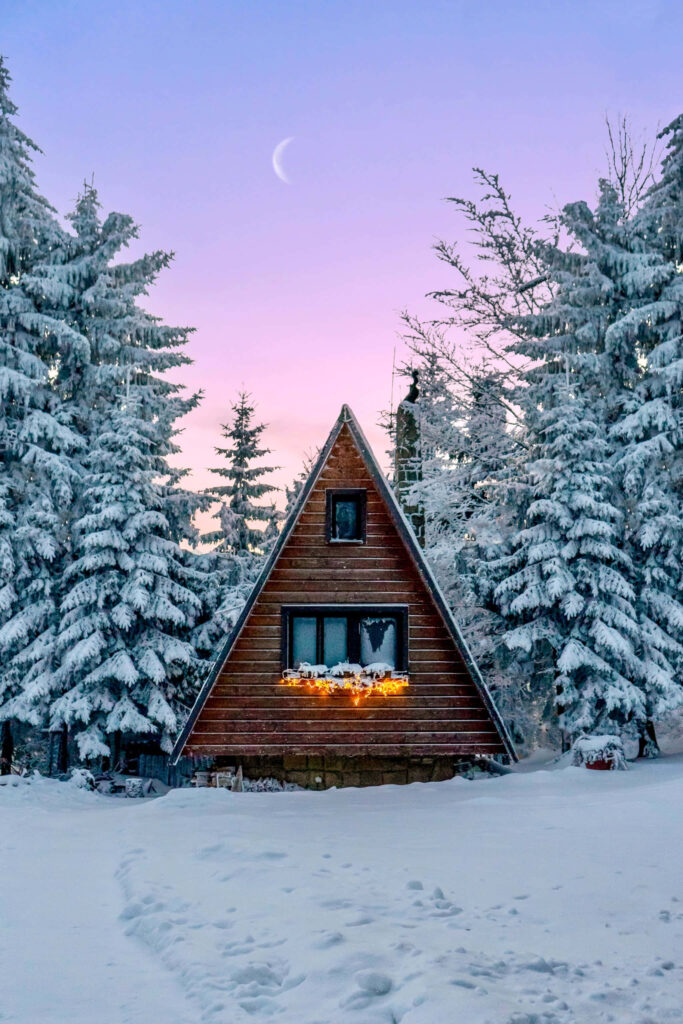 Winter Wonderland: Cozy A-Frame Cabin Amid Snowy Trees Wallpaper