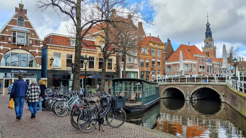 Charming Alkmaar street scene with Dutch architecture bicycles canal and picturesque bridge wallpaper