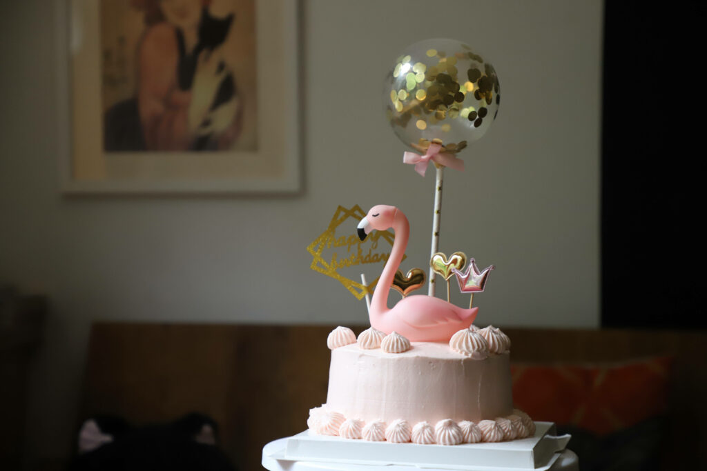 Charming Birthday Cake with Pink Frosting & Fondant Flamingo Decor Wallpaper