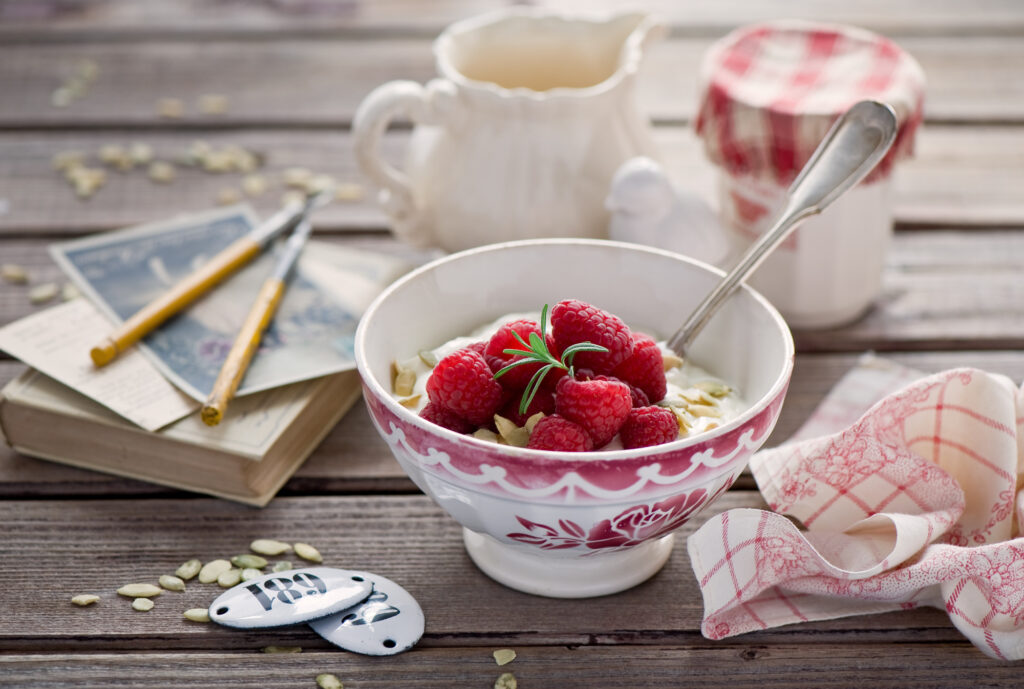 Charming Breakfast Scene: Yogurt with Raspberries & Rustic Accents Wallpaper