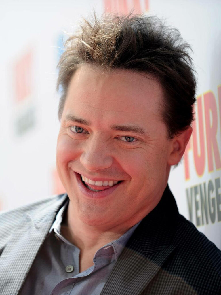 Brendan Fraser smiling candidly at red carpet event with soft blurred background wallpaper