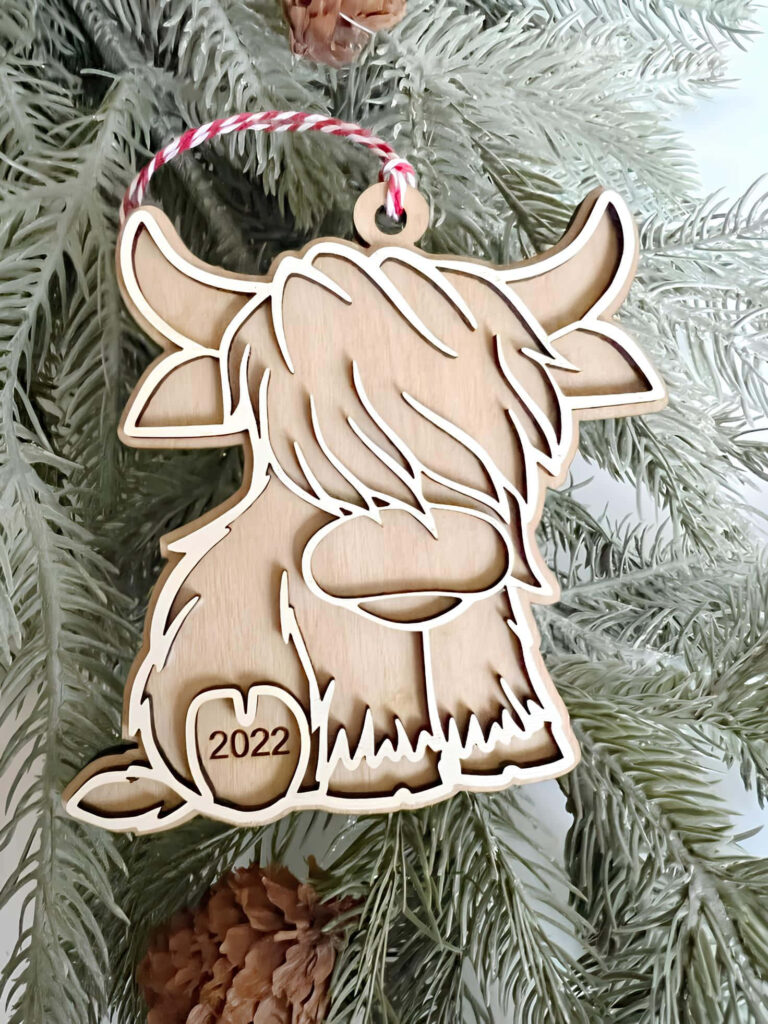 Charming Cartoon Cow Ornament on Evergreen: Rustic Holiday Wallpaper