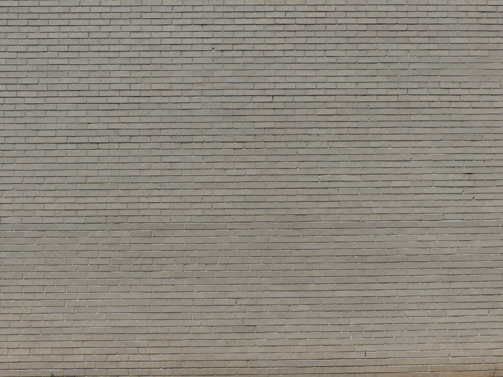 Minimalist grey brick wall with uniform pattern and neutral tones industrial wallpaper background
