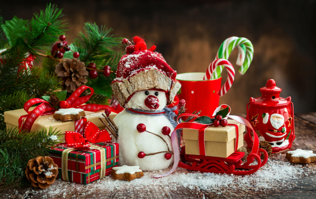 Charming Christmas Scene: Snowman in Cozy Red Hat with Festive Decor Wallpaper