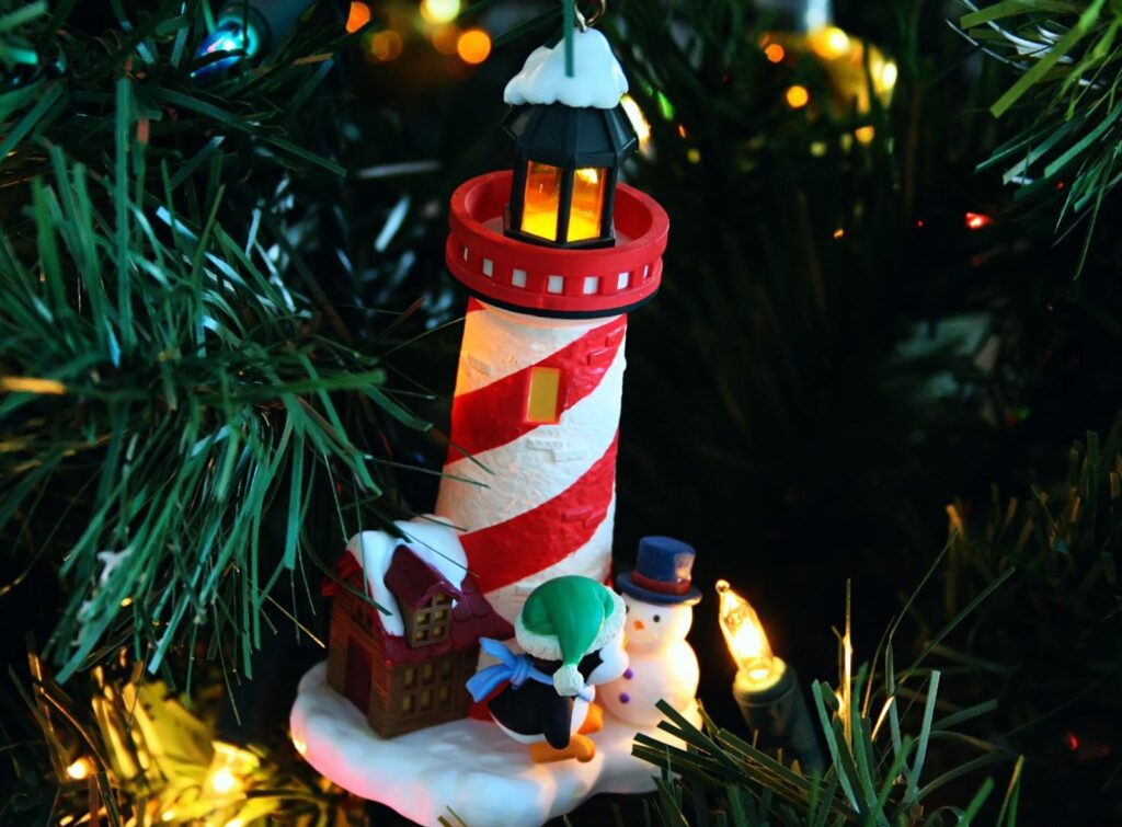 Charming Festive Lighthouse Ornament with Penguin & Snowman Wallpaper