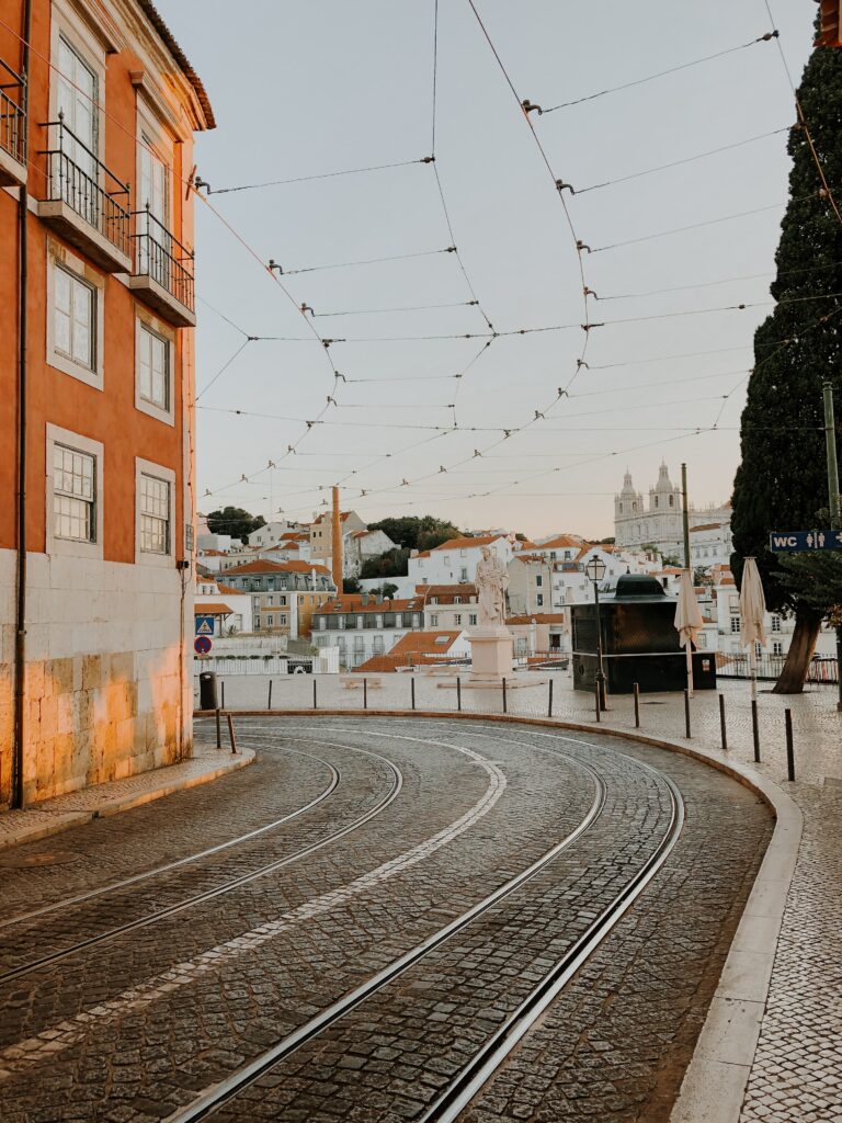 Charming Cobblestone Cityscape with Tram Rails & Warm Sunlight Wallpaper